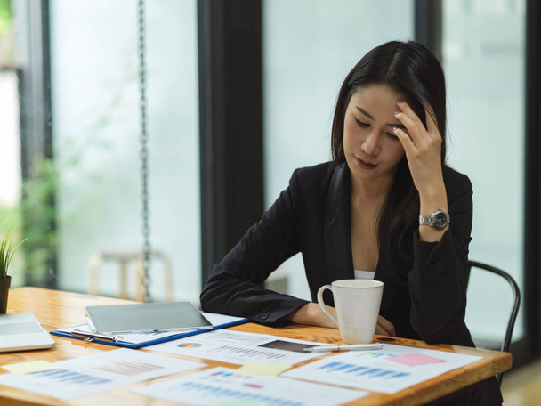 Businesswoman thinking and stressing out about business plan for next year with business reports, tablet on table, attractive businesswoman  - Foto, Imagen