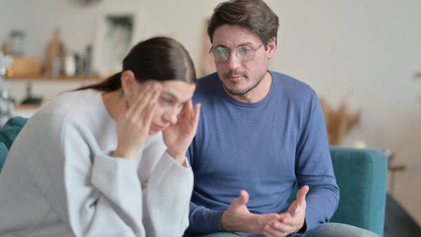 Mann streitet, während Frau sich zu Hause gestresst fühlt  - Foto, Bild