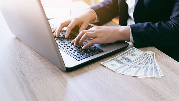 biznesmeni pracujący z laptopem w biurze, notebooka i Nas Dolarów rachunek na drewnianym stole, koncepcja biznesu - Zdjęcie, obraz