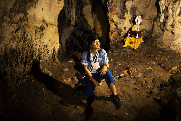 Азійські мандрівники, які відвідують і виставляють портрет у кам'яній печері Tham krasae біля пекельного полум'я проїжджають гору і сі сават або річка квай у національному парку Сай Йок Вотерфоллз у Канчанабурі, Таїланд. - Фото, зображення