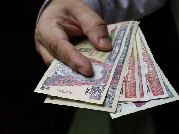 Guatemala banknotları tutan bir adamın eli. - Fotoğraf, Görsel