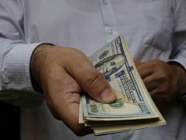 main d'un homme tenant des billets en dollars américains - Photo, image