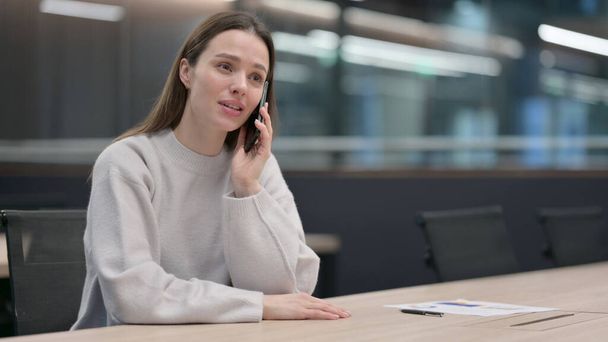 Nő beszél telefonon a munkahelyen, vita - Fotó, kép