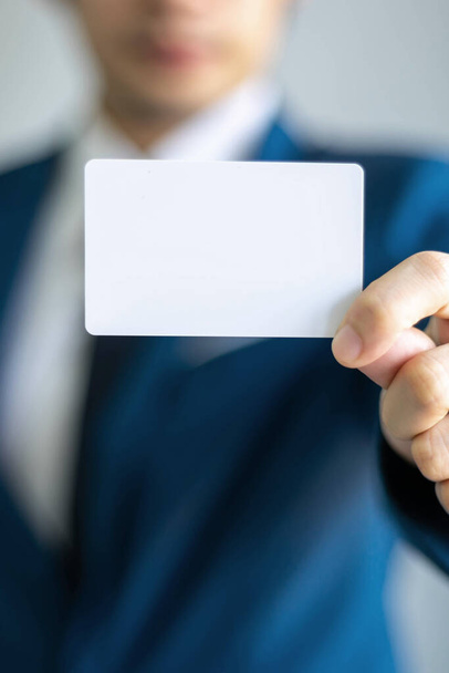 hombre de negocios sosteniendo y mostrando tarjeta de visita vacía o tarjeta de nombre - concepto de negocio - Foto, Imagen