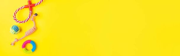 Juguetes de cuerda de perro sobre fondo amarillo, banner web - Foto, Imagen