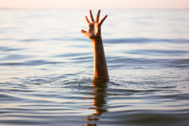 Человек тонет в воде. Рука выглядывает из-под воды. Утопающему нужна помощь, спасение. Риск, опасность для жизни в море, реке, океане, пруду. Смерть, SOS концепция. Утонувшая жертва - Фото, изображение