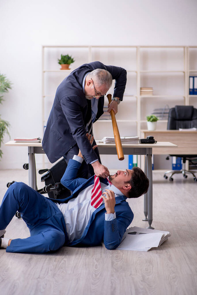 Old boss and young male employee in bullying concept - Photo, Image