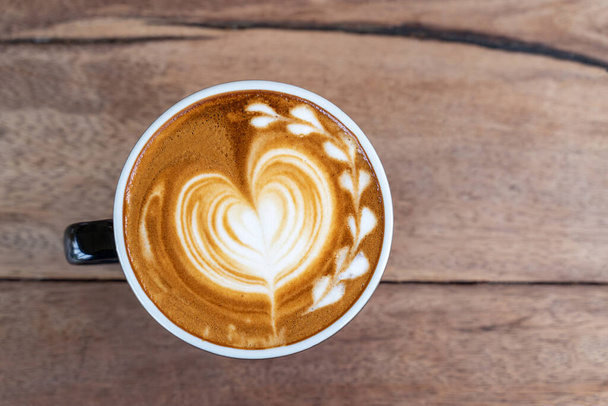Hot art káva cappuccino v šálku na dřevěném stole pozadí s kopírovacím prostorem - Fotografie, Obrázek