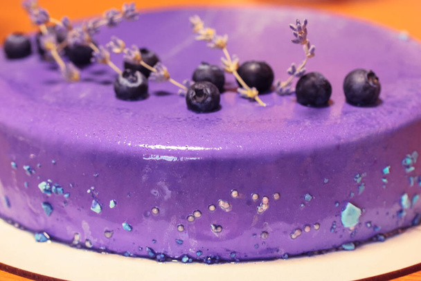 Délicieux gâteau aux myrtilles décoré de baies fraîches bleues noires, de perles, de branches de fleurs de lavande de près. Un gâteau d'anniversaire appétissant. Délicieux gâteau aux myrtilles. Recette pour la cuisson à la maison et dans une pâtisserie - Photo, image