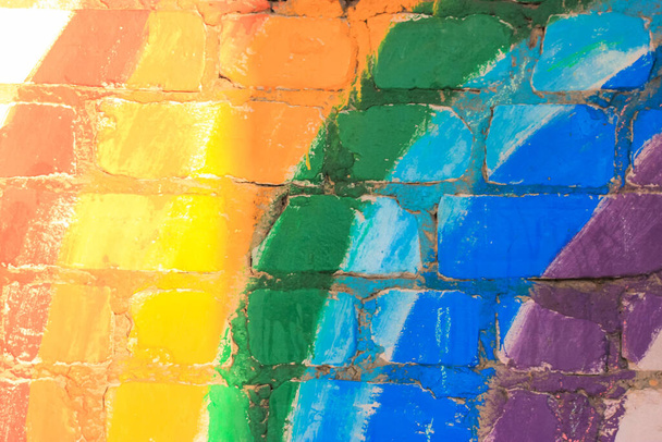A rainbow painted on an old brick wall. Seven colors - red, orange, yellow, green, blue, indigo, purple. Gay LGBT flag, pride rainbow. Also a symbol of gratitude for the NHS during Covid-19 pandemic. - Photo, Image