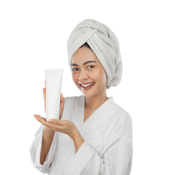 attractive woman in towel with presenting hand presenting white tube bottle - Fotoğraf, Görsel