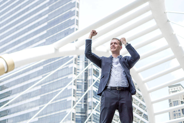 Successful business man celebrating with arms up on business district , business concept - Photo, Image