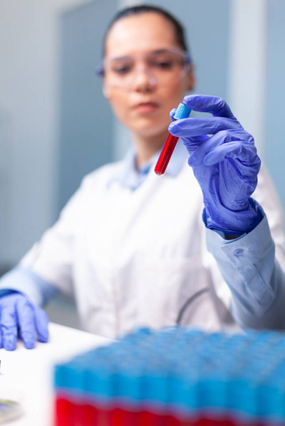 Especialista mujer doctor holding sangre médico vacutainer analizar ADN infección experiencia - Foto, Imagen