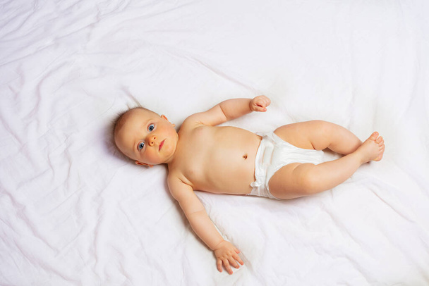 Little baby boy lay on the white in bed sheet view from top - Photo, image