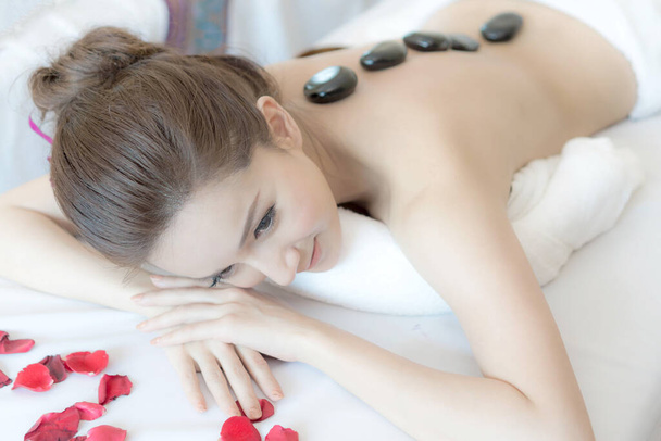 primer plano hermosa y saludable mujer durante un masaje de terapia de piedra de espalda en el salón de spa - Foto, imagen