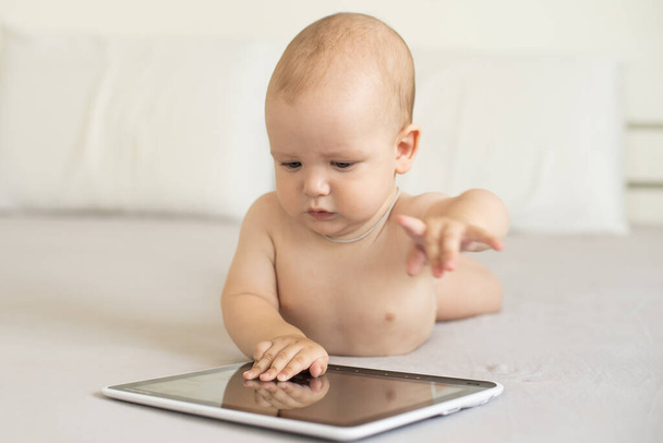 白に隔離されたデジタルタブレットで遊んでいる赤ちゃんの男の子 - 写真・画像
