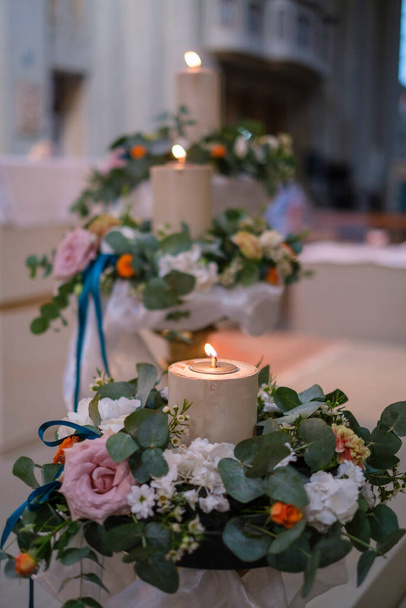 Katolik düğünü için sunaktaki çiçeklerle süslenmiş mum. Yüksek kalite fotoğraf - Fotoğraf, Görsel