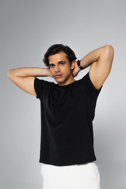 young stylish man in black t-shirt posing isolated on grey - Photo, Image