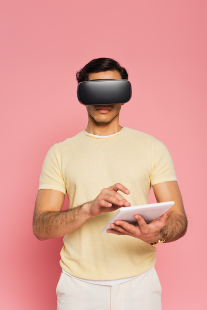 man in vr headset using digital tablet isolated on pink - Foto, afbeelding