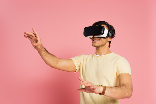 cheerful man in vr headset gesturing on pink - Foto, immagini