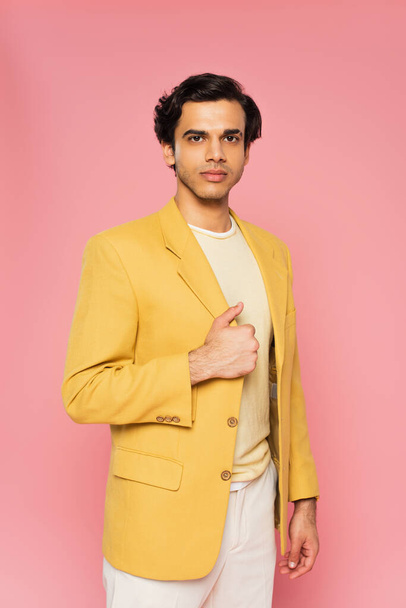 young man in trendy yellow blazer posing isolated on pink  - Fotó, kép
