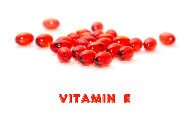 Detailní průhledné červené kapsle s vitamínem E izolované na bílém pozadí. - Fotografie, Obrázek