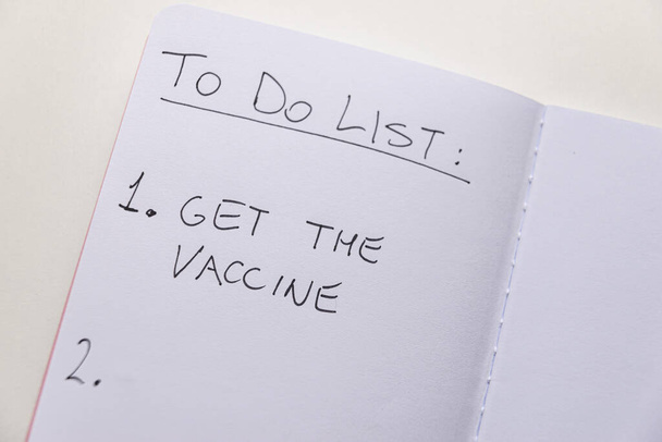 Page blanche du journal, avec le texte "À faire liste" et "obtenir le vaccin". Administration de vaccins ; doivent être vaccinés volontairement. Carte verte.  - Photo, image