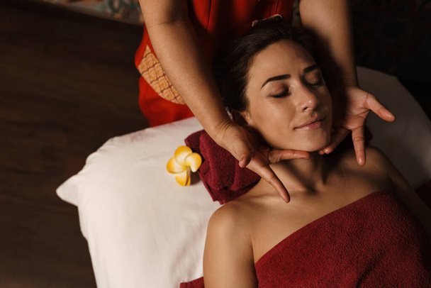 Brunette woman getting a back massage in a spa salon - 写真・画像