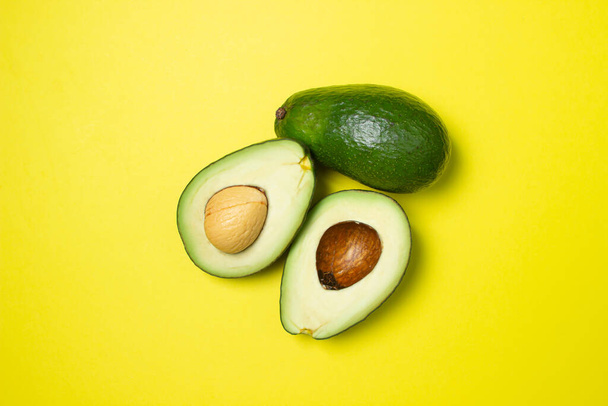 Avocado on a yellow background. Cut avocado on colored background - Foto, immagini