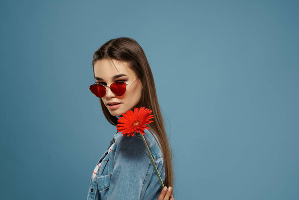красивая брюнетка в солнечных очках красный цветок элегантный стиль модели - Фото, изображение