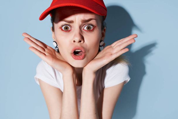 έκπληκτη κοπέλα σε ένα κόκκινο καπάκι φωτεινό μακιγιάζ διακόσμηση μόδας καλοκαίρι - Φωτογραφία, εικόνα
