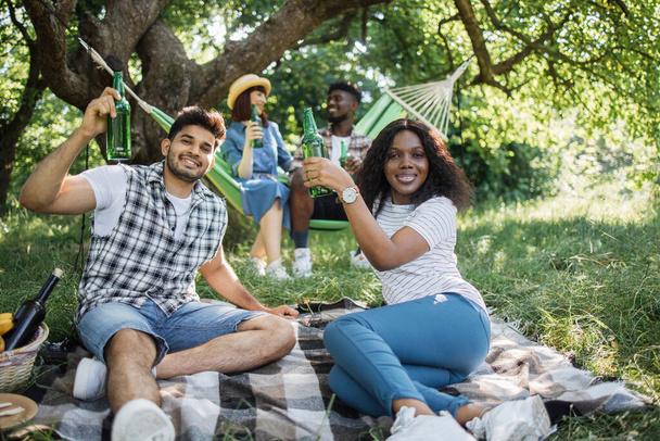 Щасливі різноманітні друзі насолоджуються пікніком на відкритому повітрі
 - Фото, зображення