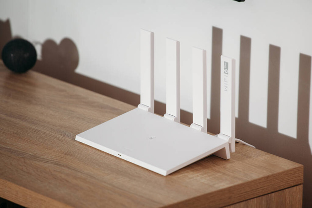 Белый Wi-Fi 6 роутер с четырьмя экранами на мансардном столе. - Фото, изображение