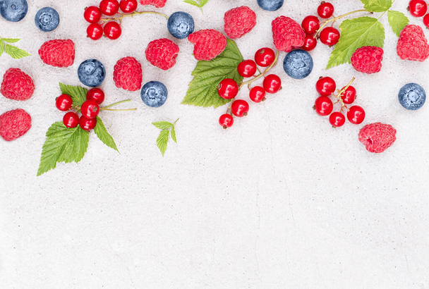 juicy berries of raspberries, blueberries and red currants on a concrete background - Φωτογραφία, εικόνα