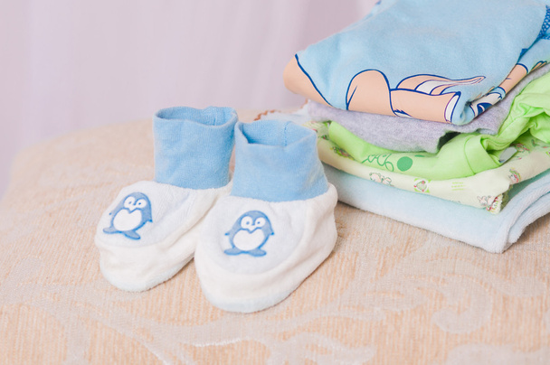 Baby booties and clothes folded - Photo, Image