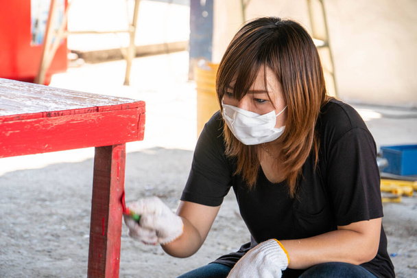 Egy nő kesztyű javítás asztal festék ecset. Pirosban. Festék ecset mition elmosódás. - Fotó, kép