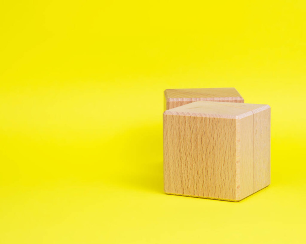 Two wooden cube square on yellow background copyspace - Foto, Imagen