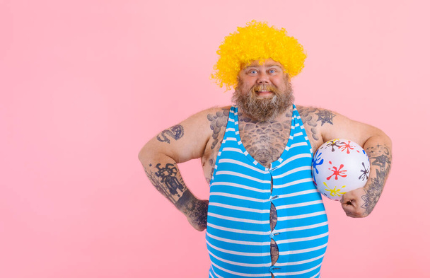 Gros homme heureux avec barbe et perruque jouer avec la balle - Photo, image