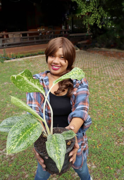 Belle de l'Asie femme portrait heureux sourire planté plante avec de la terre dans le pot - Photo, image