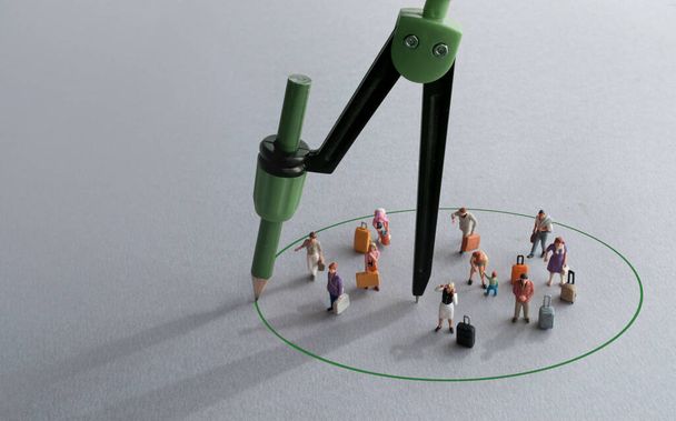 Compass with green pencil circle around miniature travellers representing restriction free zones - 写真・画像