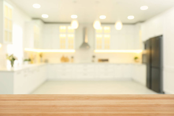 Empty wooden table and blurred view of stylish kitchen interior. Mockup for design - Fotografie, Obrázek