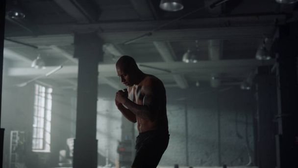 Άνθρωπος εξάσκηση kickboxing στο γυμναστήριο. Guy γροθιές κατάρτισης κατά τη διάρκεια της άσκησης καρδιο - Φωτογραφία, εικόνα