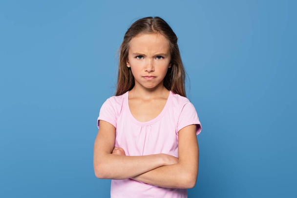 Offended girl with crossed arms looking at camera isolated on blue  - Foto, immagini