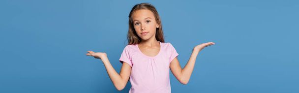 Preteen child pointing with hands isolated on blue, banner  - Foto, afbeelding