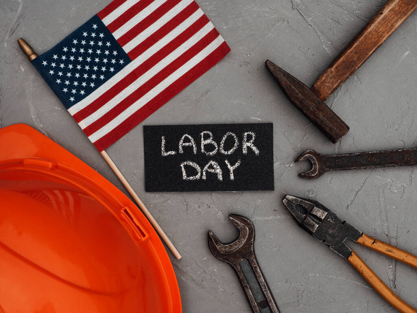 LABOR DAY. Hand tools and the Flag of the United States of America lying on the table. View from above, close-up. Congratulations to family, relatives, friends and colleagues. National holiday concept - 写真・画像