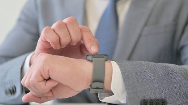 Mains Gros plan de l'homme d'affaires en utilisant Smart Watch  - Photo, image