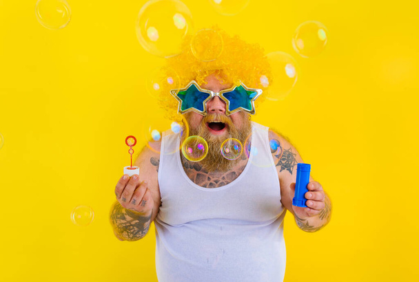 Дивовижний чоловік з жовтим перцем в голові грає з милом бульбашок
 - Фото, зображення