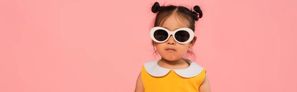 asian toddler girl in dress and sunglasses posing isolated on pink, banner - Φωτογραφία, εικόνα
