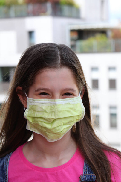 nice girl with long black hair and green mask to protect herself from coronavirus - Photo, Image