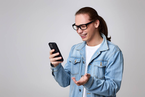 young man in glasses using smart phone - Fotografie, Obrázek